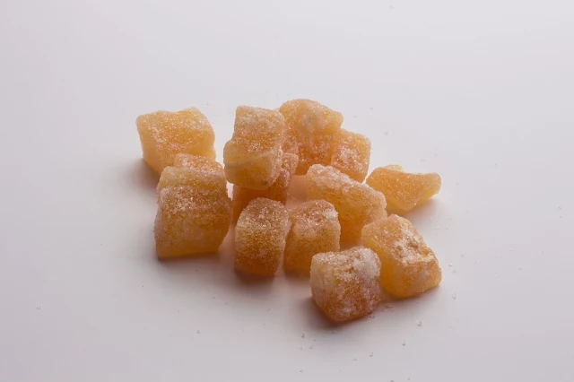 A pile of crystalised ginger on a white background