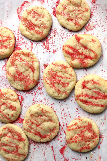 Overhead shot of Eggnog Iced Butter Cookies drizzled with red sprinkles.