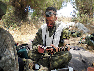 Moshe Lifshitz, a haredi (ultra-Orthodox) Israeli, wears tefillin while praying in the Israeli army. Lifshitz broke with his community's tradition when he chose to enlist in the Israeli army rather than apply for an exemption to study Torah full time. Photo courtesy of Moshe Lifshitz