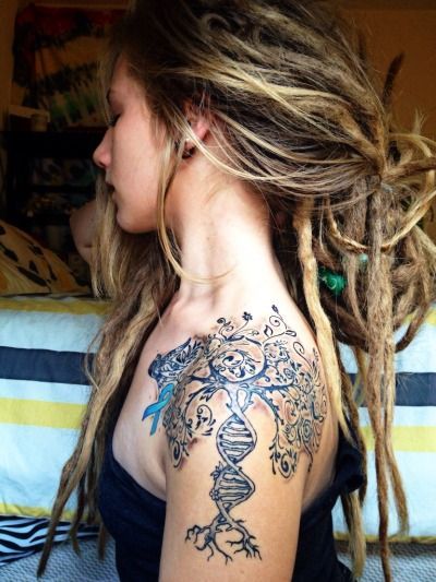 chica con rastas lleva en el hombro un tatuaje de arbol genealogico