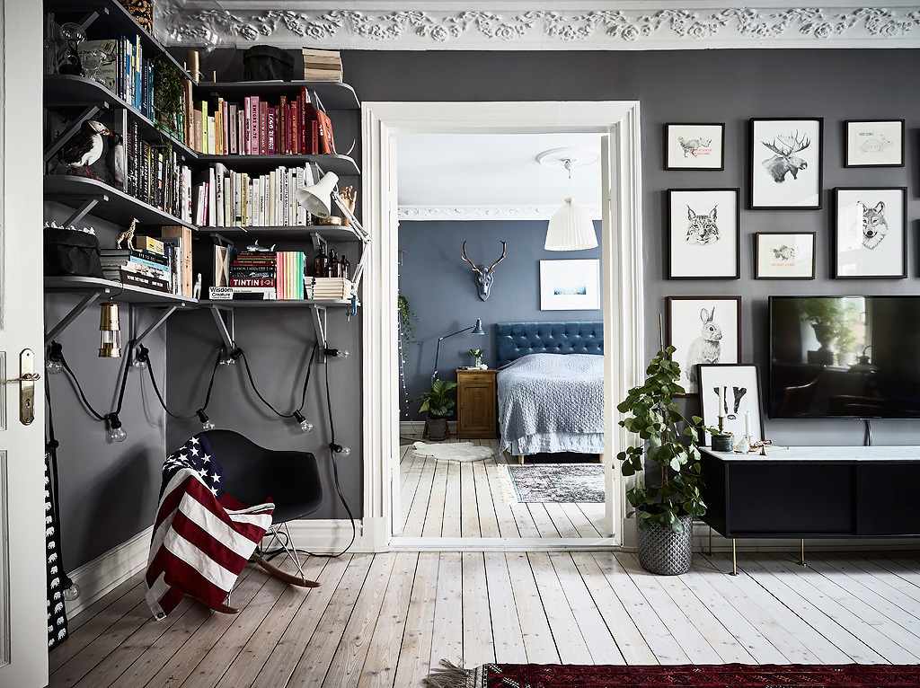 bohemian artist home scandinavian apartment  with houseplants wall art fireplace blue walls, bbookshelf