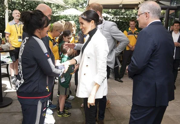 Meghan Markle wore L'agence Brea pinstriped linen and cotton-blend blazer, Wolford Colorado bodysuit, Outland jeans, carried Oroton Avalon bag.