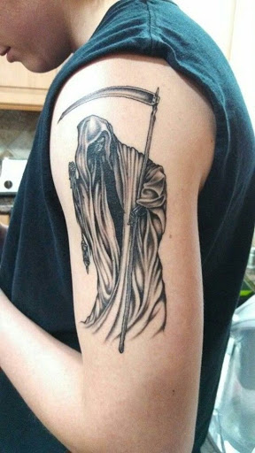 Um preto com tinta Grim Reaper tatuagem com a foice. Este é o clássico Grim Reaper concepção que as pessoas têm sido familiar. A ligeira face do reaper é mostrado e ele lhe dá um vislumbre do esqueleto da face.