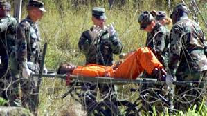 Hunger striker being taken away on guerney at Guantanamo Bay