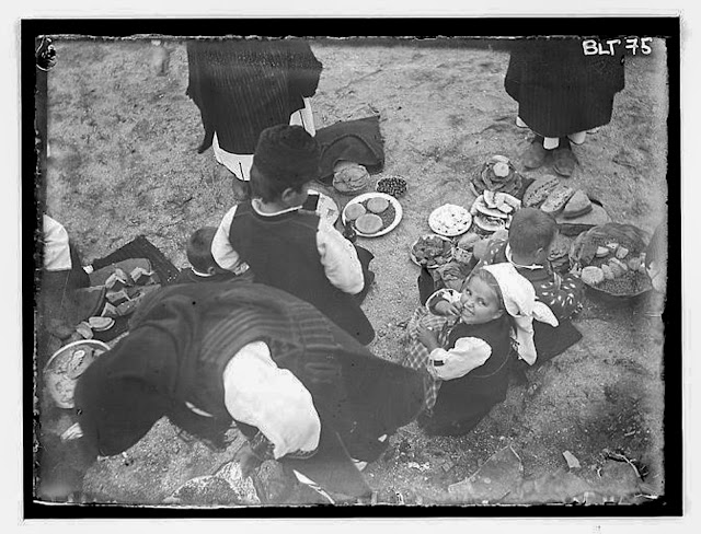 Day of celebration: woman and children around food dishes on the floor, village Negochani (Niki)
