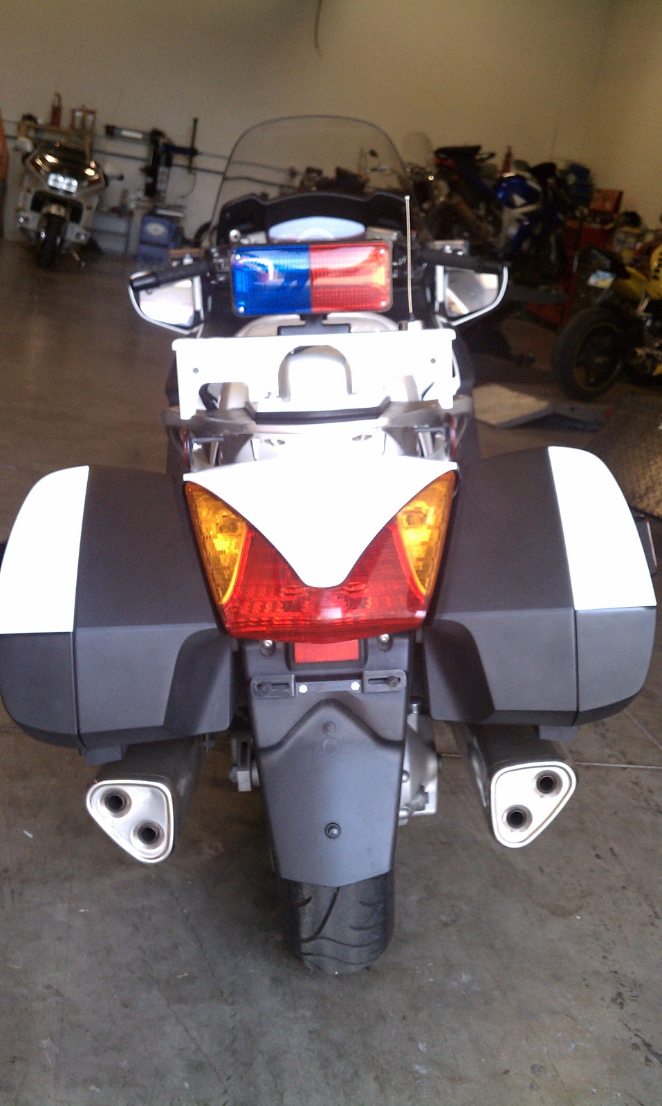 Rear of the bike. Passenger seat is replaced with a plastic cowl and additional bracket added to