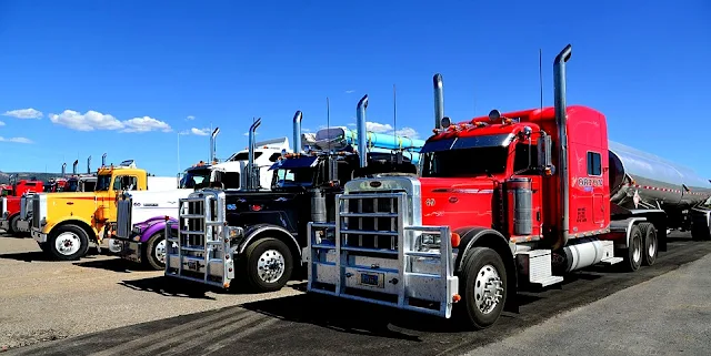 Image Attribute: The file photo of American semi-trailers in a parking lot/ Source: Pixabay.com 