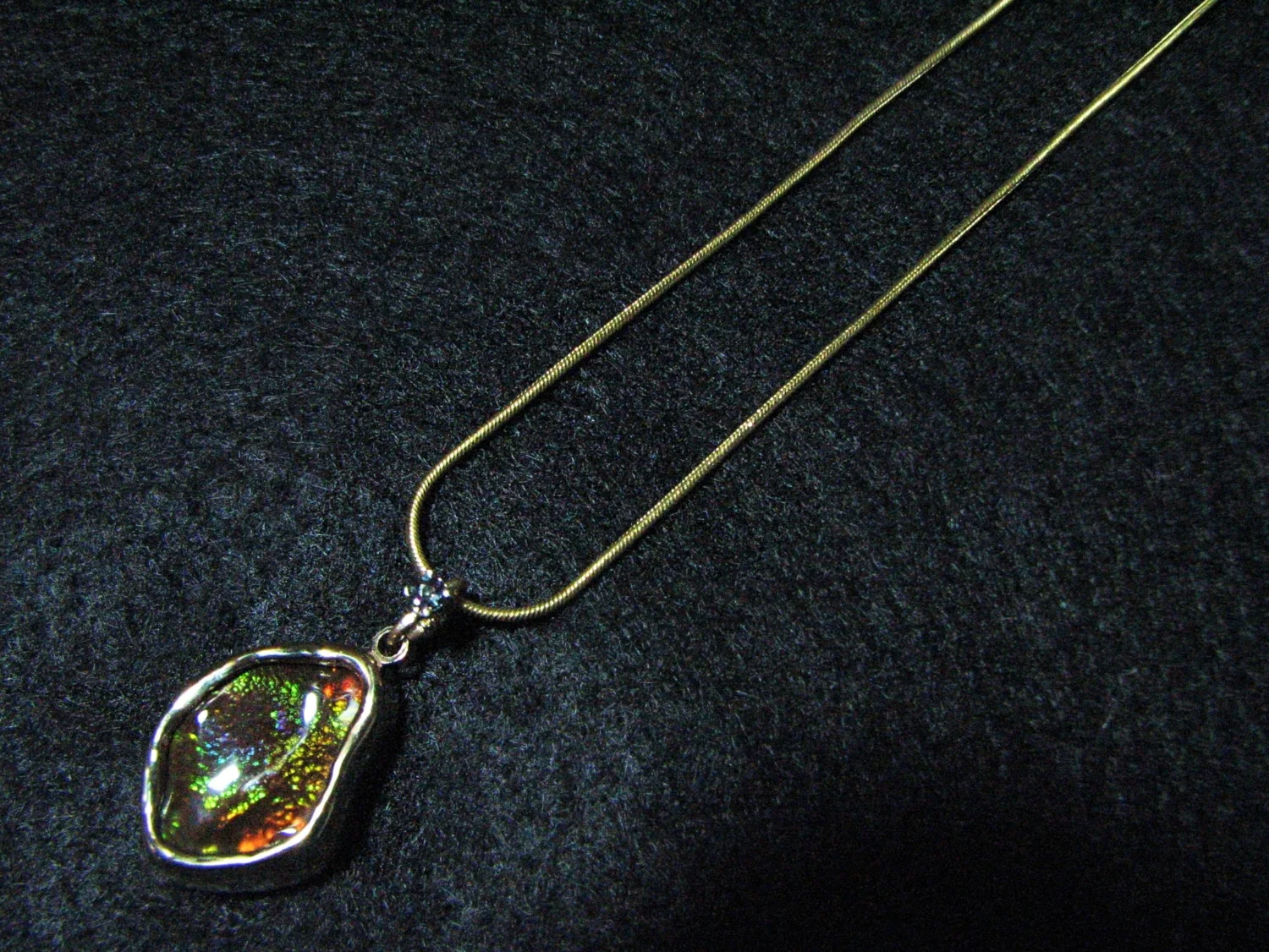 close-up of a Fire Agate and Alexandrite necklace on a black background