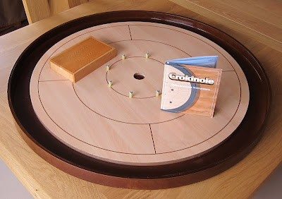 Crokinole - The large game board sitting on the end of the dinner table