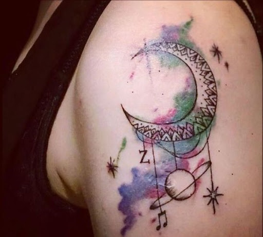 Uma lua crescente utiliza elementos de uma mandala e é manchada com aquarelas nesta peça.