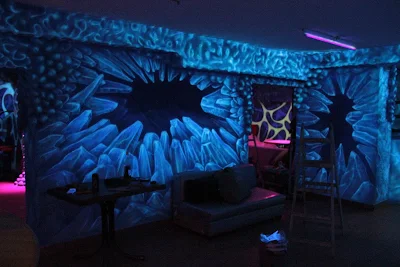 Malowanie ścian w dyskotece farbami fluorescencyjnymi świecącymi w ciemności, mural UV