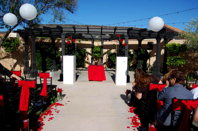 The aisle was lined with red rose petals and glass cylinders with rose 
