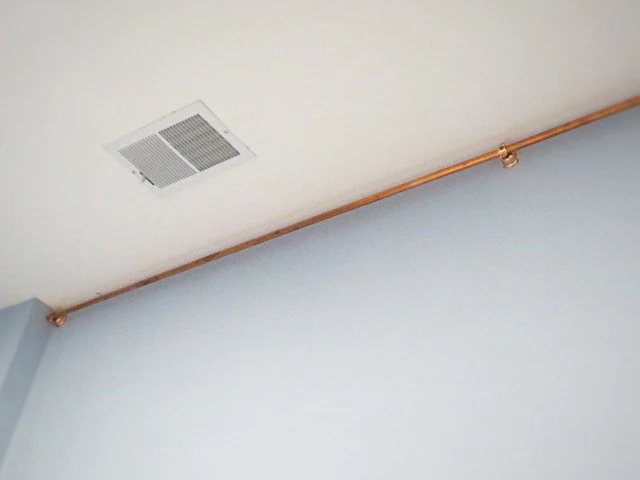 hanging copper pipe pieces at ceiling with bell hangars