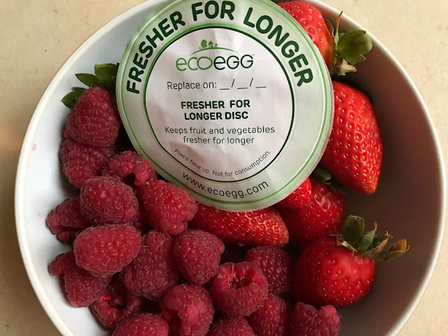a bowl full of strawberries and raspberries with a green circular piece of paper on top which says "fresher for longer"