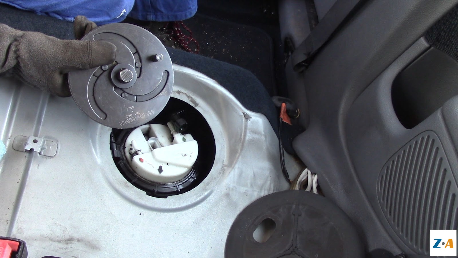 Vue sur la pompe à carburant de la Clio et sur l'outil de dépose de sa bague de serrage.