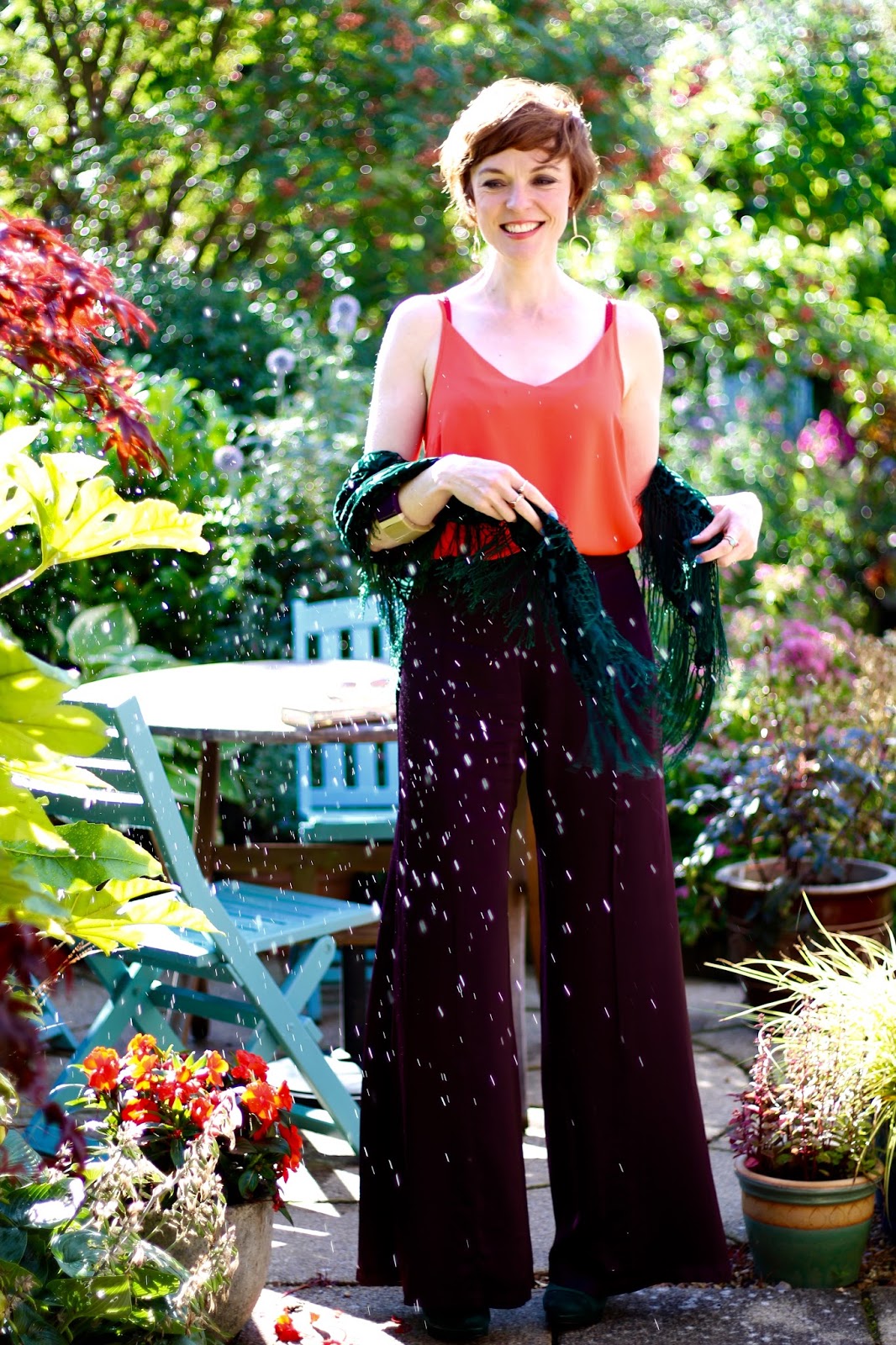 Fake Fabulous | Aubergine satin wide legged trousers, orange camisole, green velvet shawl and heels, nude clutch, over 40.