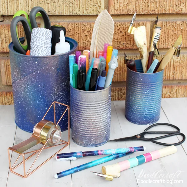 Galaxy Painted Pen Holders  Save those soup cans and turn them into pen holders! Add some paint or spray paint for the perfect galactic finish.
