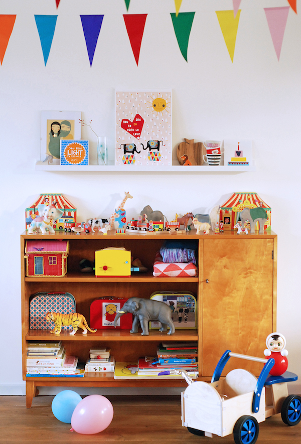 A wooden cabinet, which its top surface has a display area for kid's toys.