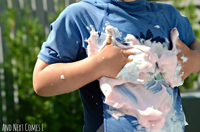 Kid rubbing colored shaving cream on their body