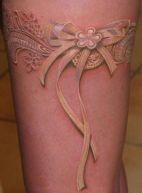 tatuaje de lazo rosa en la pierna