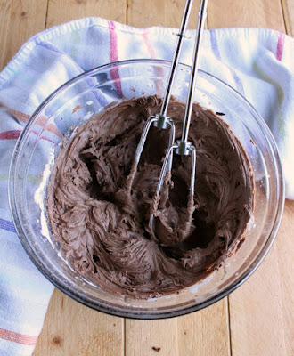 bowl of chocolate frosting with beaters
