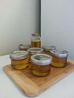 Seven finished jars of golden yellow jelly.