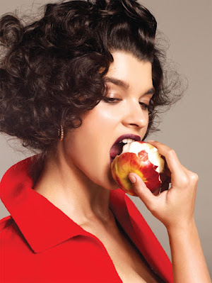 Woman Biting into an apple wearing a red jacket
