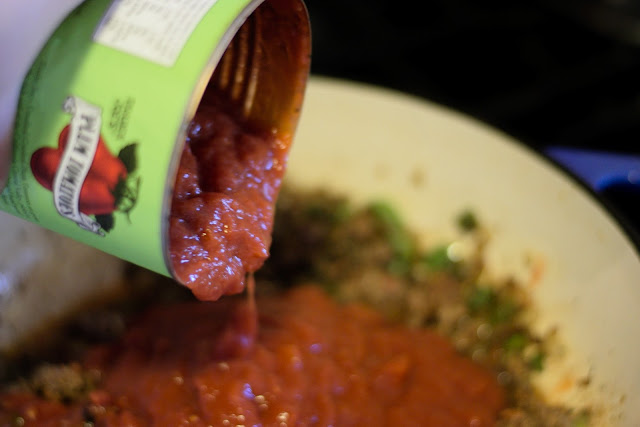 Crushed tomatoes being added to the pot. 