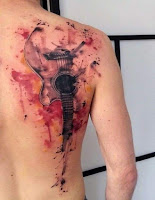 tatuaje en la espalda de guitarra a color