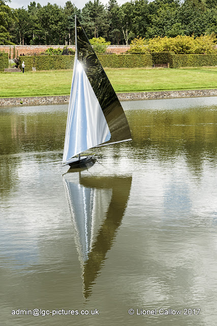 Before and After by Luke Dickinson This is a stainless steel sculpture of a yacht. It is mobile with the wind floating on the lake.