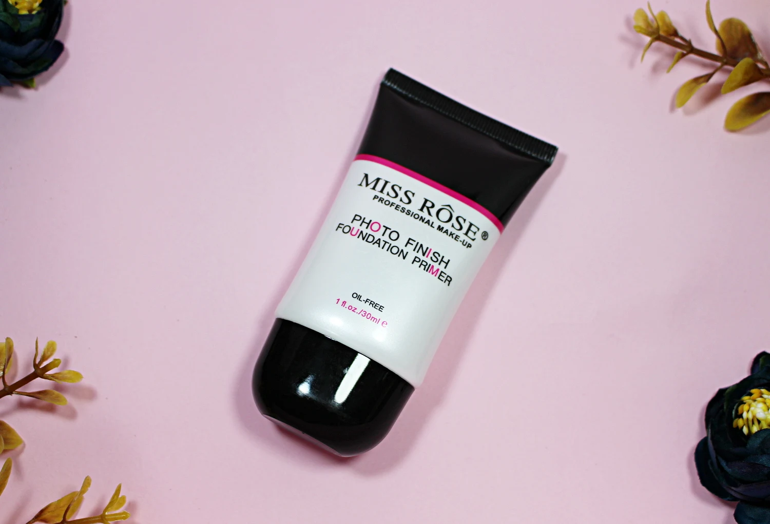 an opened tube of silicone-based makeup primer on a pink, studio's background