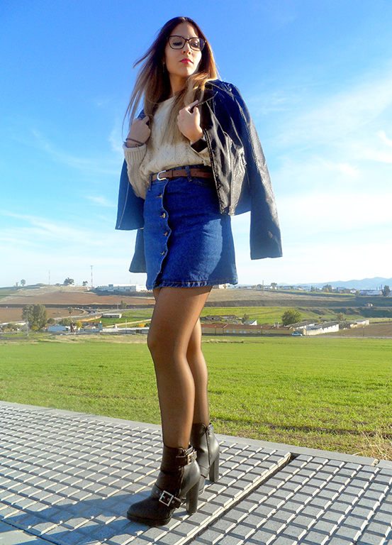 Falda denim acamapanda, jersey de punto rasgado, cazadora biker negra y botines de tacón con hebillas