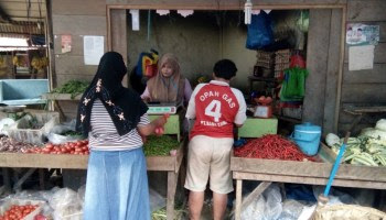 Penjual tomat dan cabai sedang melayani pembeli. Penjual tomat dan cabai sedang melayani pembeli.