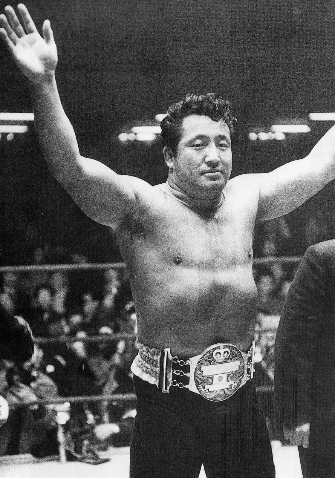 プロレスのリングでチャンピオンベルトを着けて両手を上げる力道山