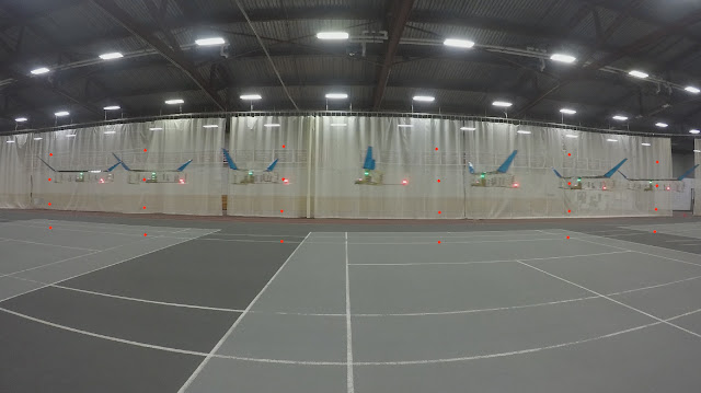 A time-lapse image showing the plane flying across a gymnasium