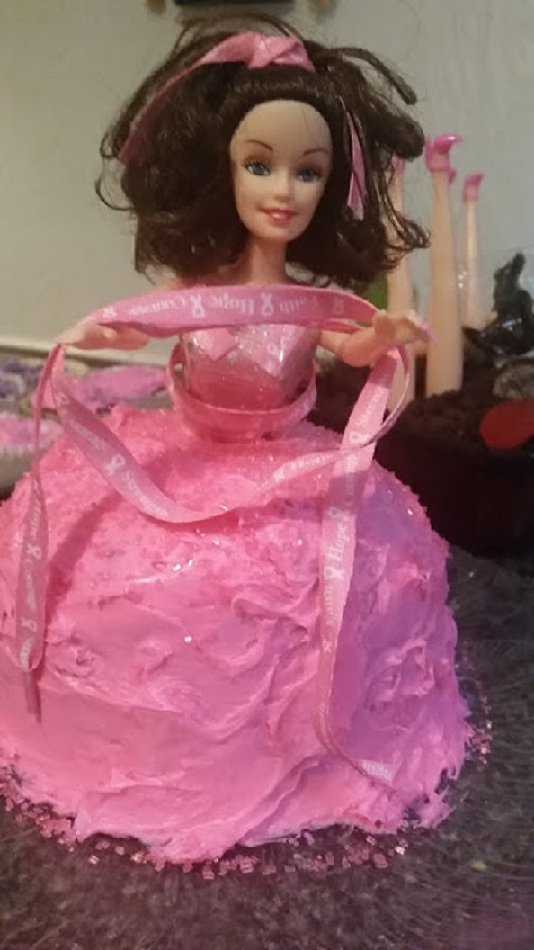 this is a doll cake with the Halloween theme  or the breast cancer awareness pink frosting doll 