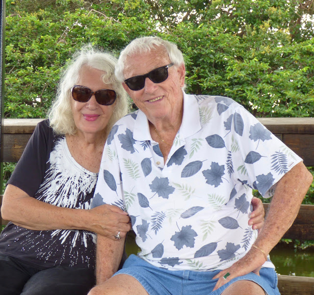 Family photo of my mother and her boyfriend smiling and wearing dark sunglasses in the Florida sunshine.