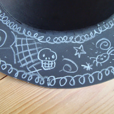 A witches hat brim decorated with halloween doodles.