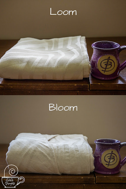[Image is a collage of two photos featuring a natty woven wrap with an abstract geometric pattern on an old wooden sewing table, sitting nicely folded next to a purple ceramic mug with a fancy B. The top photo is of the woven wrap pre-wash state, and the text Loom. The bottom photo is of the woven wrap post-wash and post-line dry, and with the text Bloom. The purpose is to show the transformation a woven wrap goes through between loom state and post-first wash and for visual cush.]