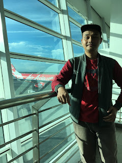 Dimas dengan background pesawat AirAsia di KLIA 2