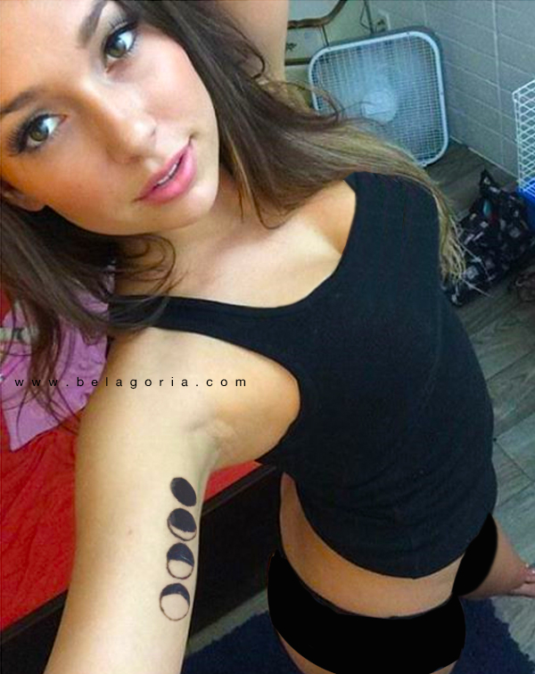 Vemos a una joven sacandose una foto en su habitacion, lleva tatuaje de fases lunares en el brazo