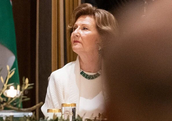 Satin blouse. Queen Sonja wore gold diamonds and emerald necklace. Queen Sonja wore gold and diamond leaf earrings.