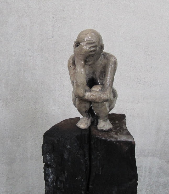 Rzeźba współczesna przedstawiająca siedzącą postać