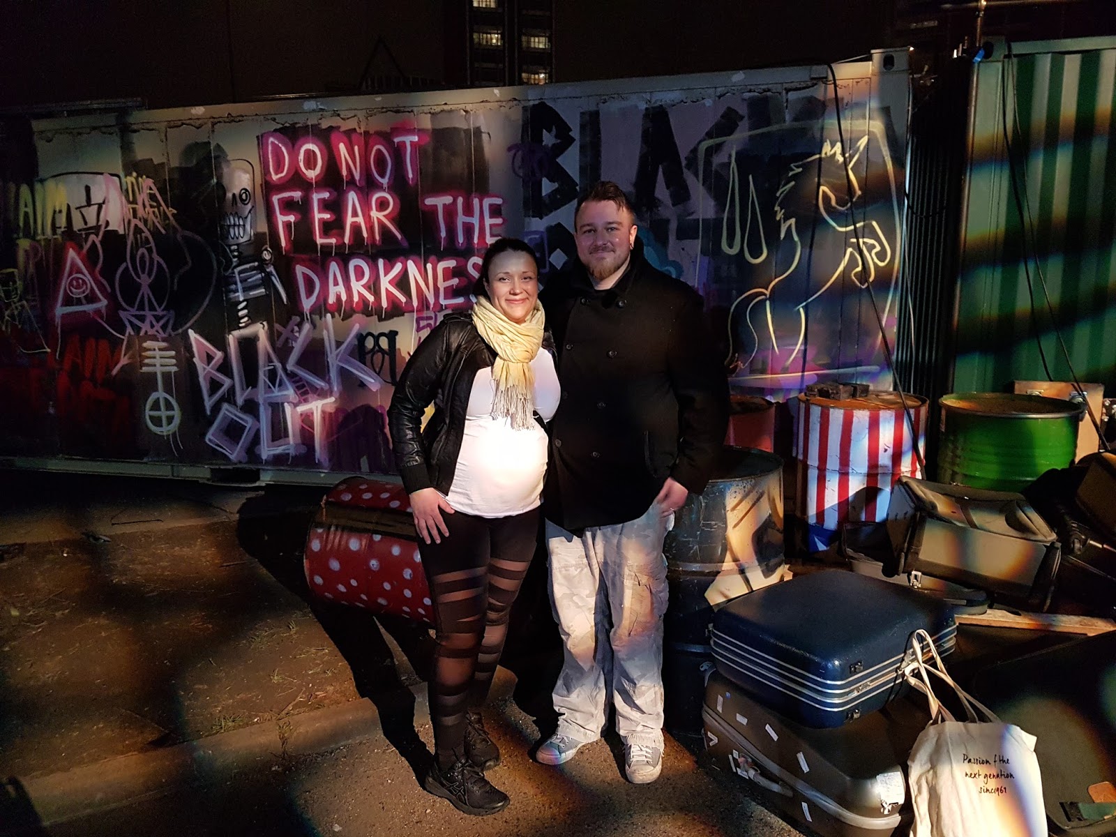couple standing in front of graffiti