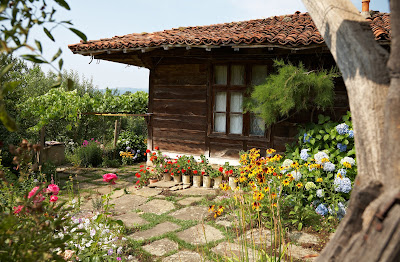 Casa de Madera con plantas y flores en el jardín.