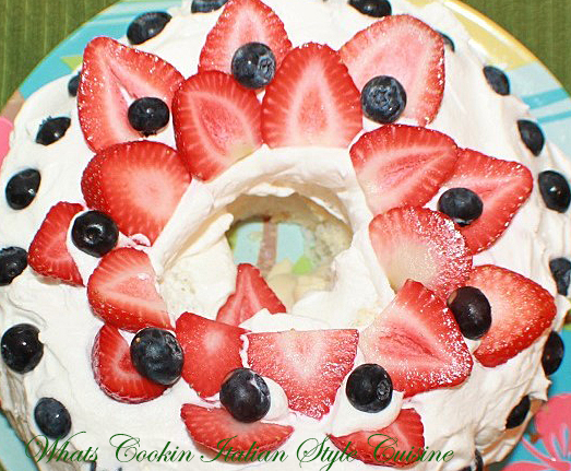 This is an angel food cake that's sugar free with sugar free vanilla pudding inside and decorated with whipped cream, strawberries sliced and blueberries for a patriotic themed party for the 4th of July