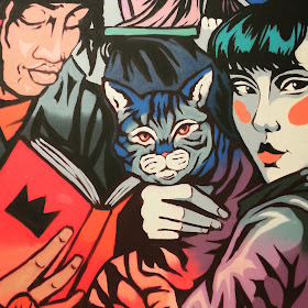 Mural featuring a cat, a Japanese girl and a man reading a book.