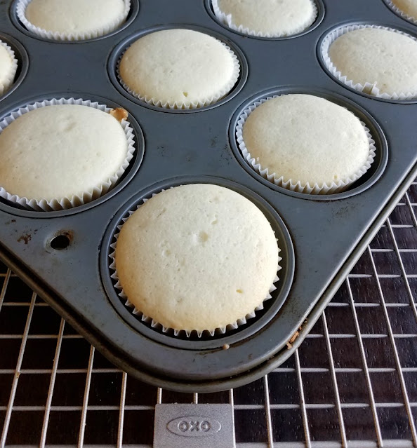 fresh baked white cupcakes in tin white cupcakes fresh from oven in tin on wire rack