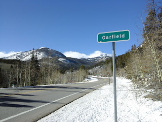 Garfield highway sign on a sunny day with snow all around.  Mountain view along the highway.