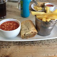Adults portion of sausage roll, chops and beans